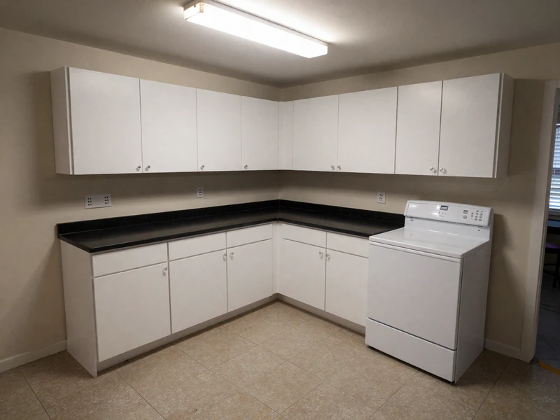 Before: Small condo kitchen in University Park Irvine with white melamine cabinets and limited storage